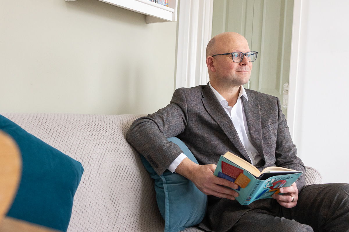 Michael Hewstone, Leadership Coach reading on a sofa